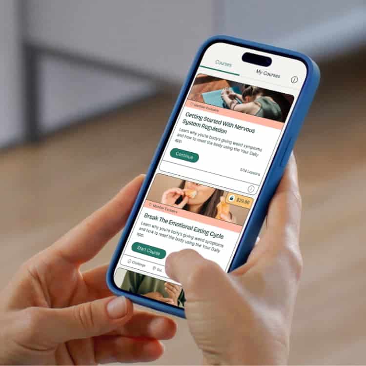 A person holds a smartphone displaying an online course app with lessons on nervous system regulation and breaking the emotional eating cycle.